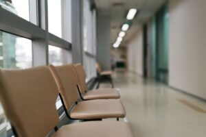 Stuhlreihe in einem hellen Klinikflur am Fensterband